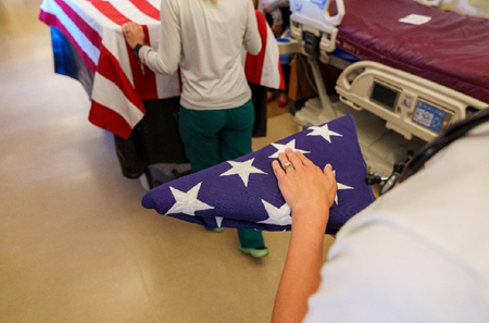 An employee holds the folded flag before giving it to the veteran’s next of kin